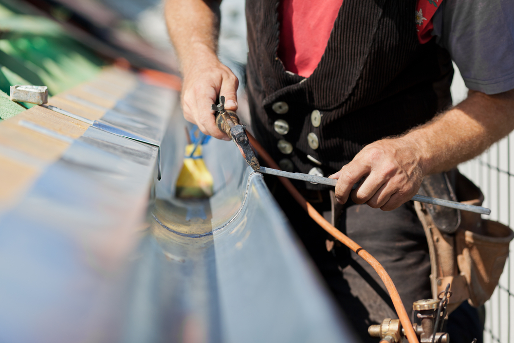 Close-up,Of,A,Roofer,Applying,Weld,Into,The,Gutter,Parts